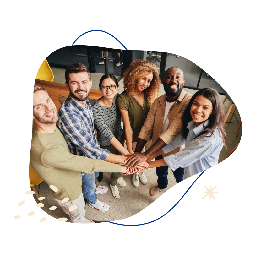 Diverse group of six smiling professionals stacking hands, symbolizing teamwork and unity.